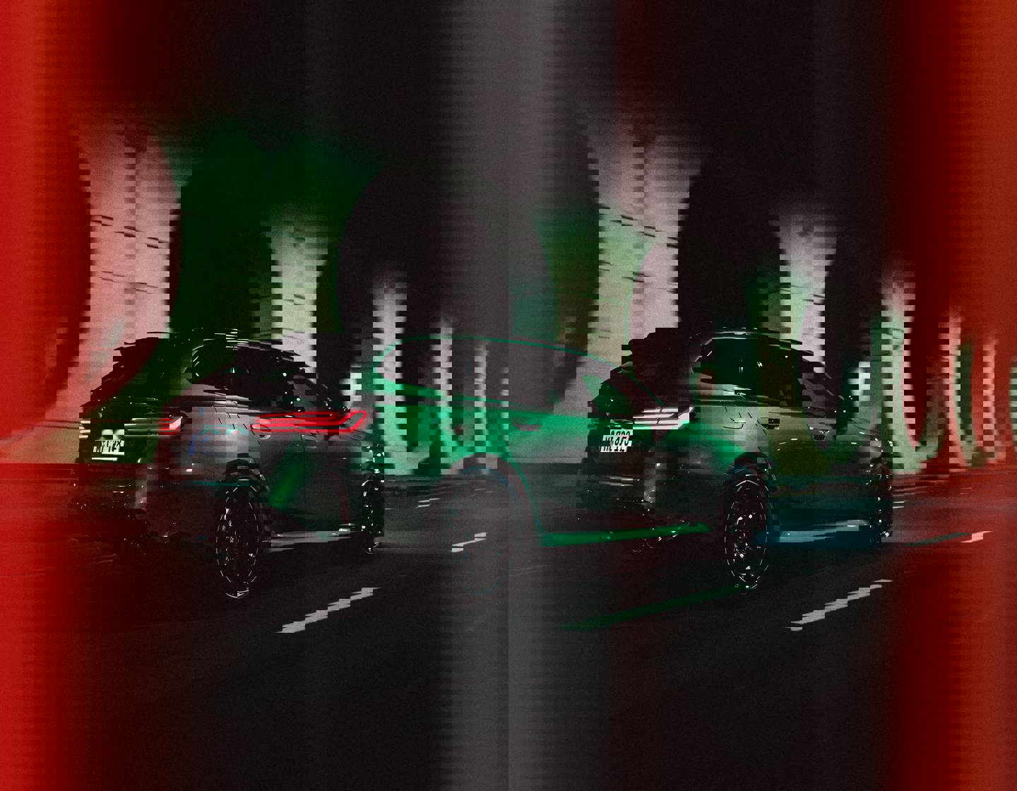 BMW M5 Touring in Grün, von hinten fotografiert, fährt durch einen beleuchteten Tunnel bei Nacht.