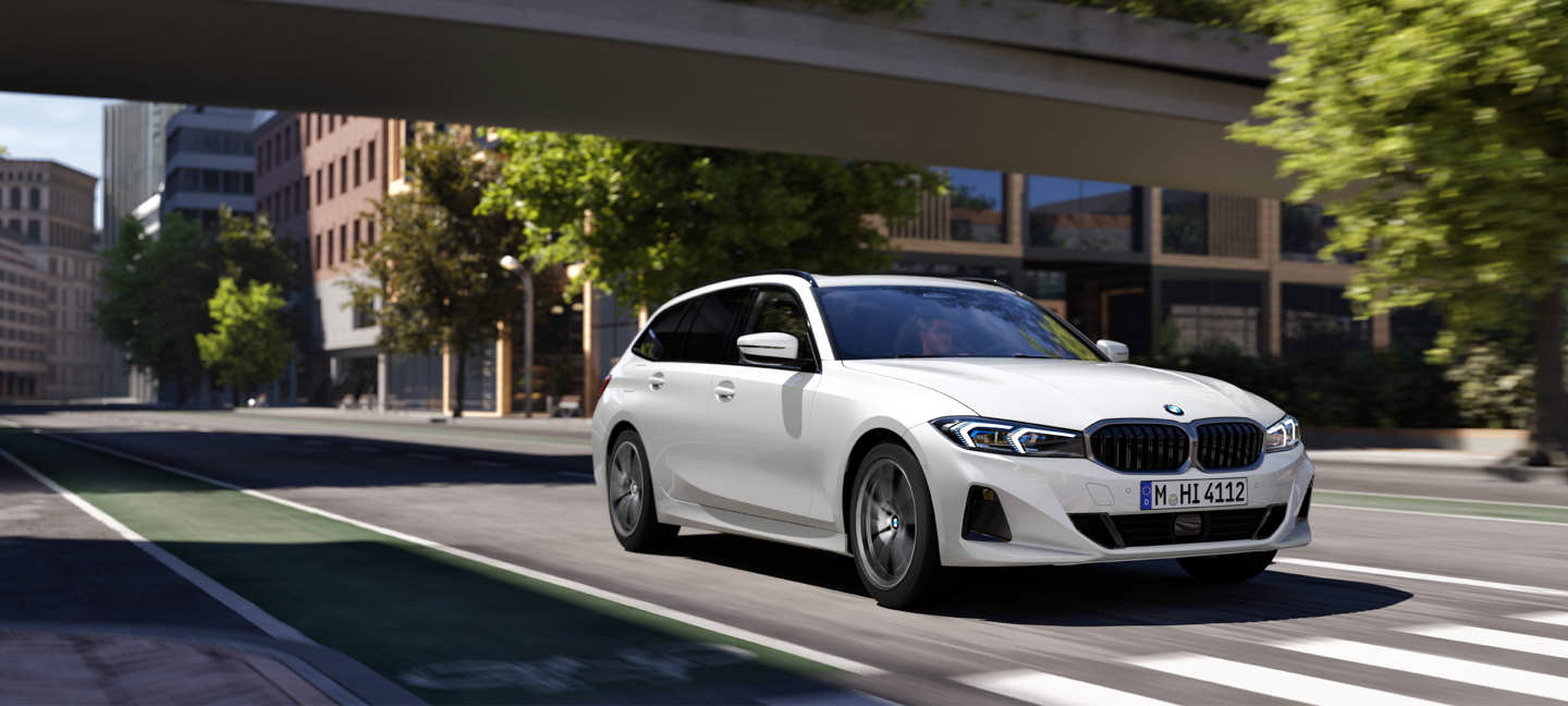 BMW 3er Touring in weiß als sportlicher Kombi in dynamischer Fahrszene in einer modernen Stadt, unterwegs auf einer mehrspurigen Straße unter einer Brücke, umgeben von urbaner Architektur und grünen Bäumen, modernes Premiumfahrzeug mit Fokus auf Fahrdynamik und Alltagstauglichkeit ohne eingeblendeten Werbetext