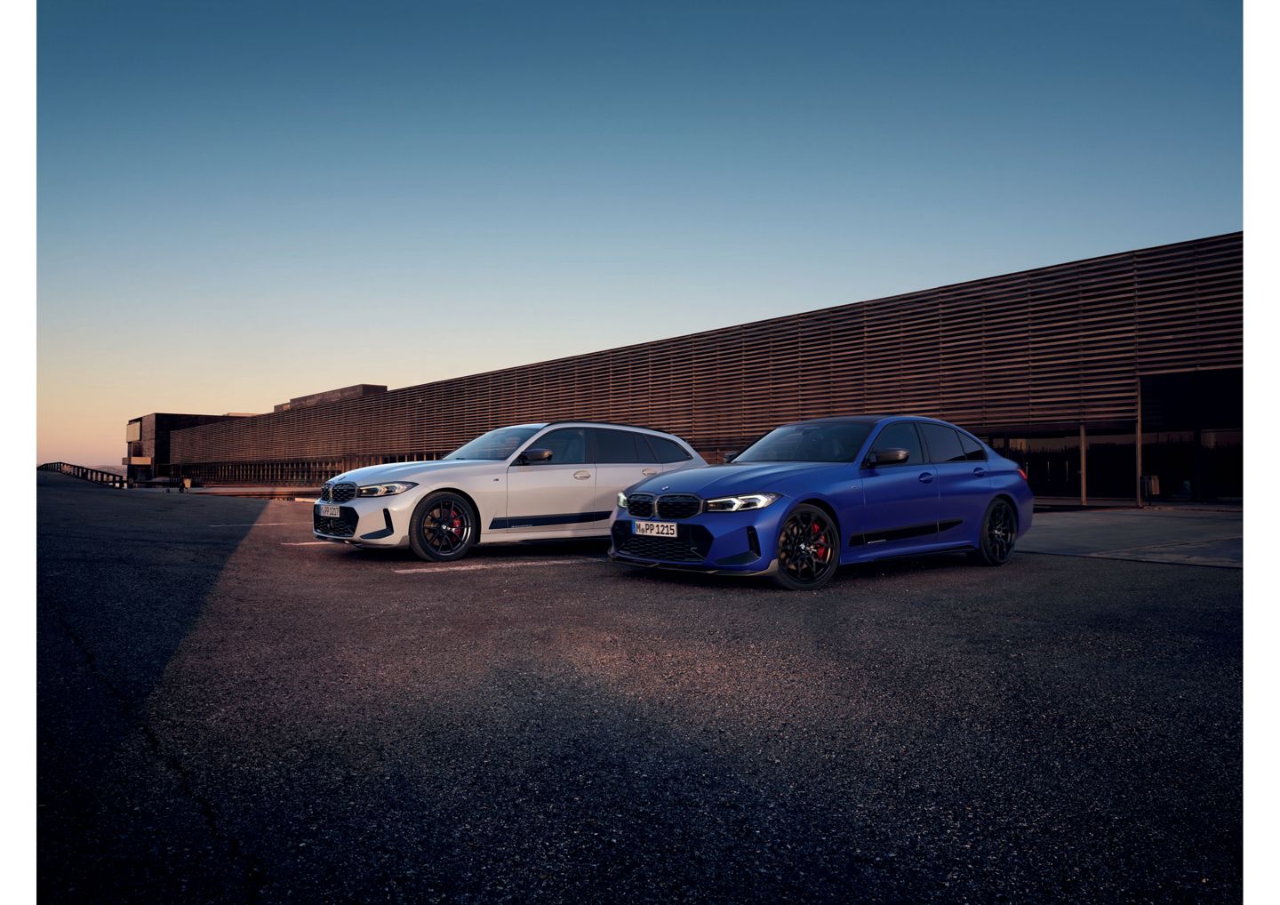 BMW 3er Touring in Weiß und BMW 3er Limousine in Blau vor moderner Kulisse bei Sonnenuntergang.“