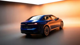 In einem modernen Studio mit heller, verlaufender Beleuchtung und glattem, spiegelndem Boden steht eine blaue BMW-Limousine.