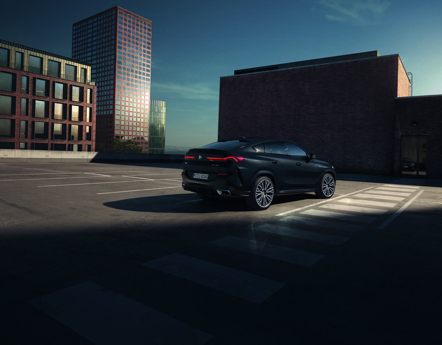 „BMW Banner der May & Olde Black Weeks. X6 in Schwarz auf einem urbanen Parkdeck – sportliches SUV mit markantem Design, fotografiert bei Sonnenuntergang.