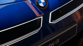 Nahaufnahme des Kühlergrills und des Emblems eines blauen BMW i3 Elektroautos.