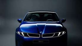 Ein blauer BMW, von vorne fotografiert in einem sanft beleuchteten Studio vor einem dunklen Hintergrund.