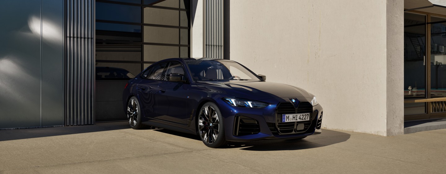 Vor einem modernen Gebäude mit großen Fenstern und hellen Wänden steht eine dunkelblaue BMW-Limousine.